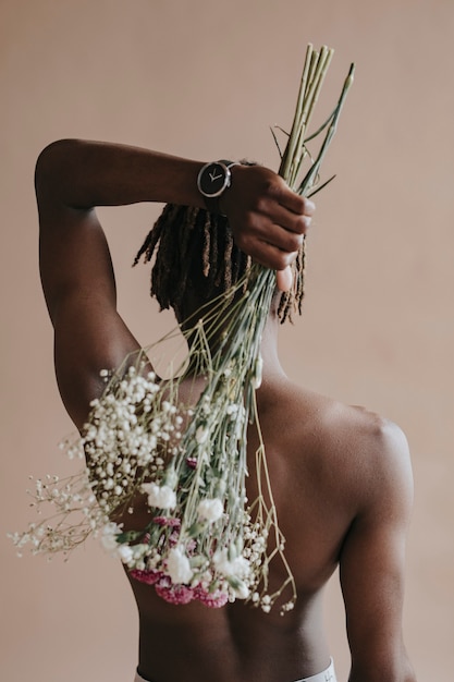 Black man carrying a bouquet of flowers on his back