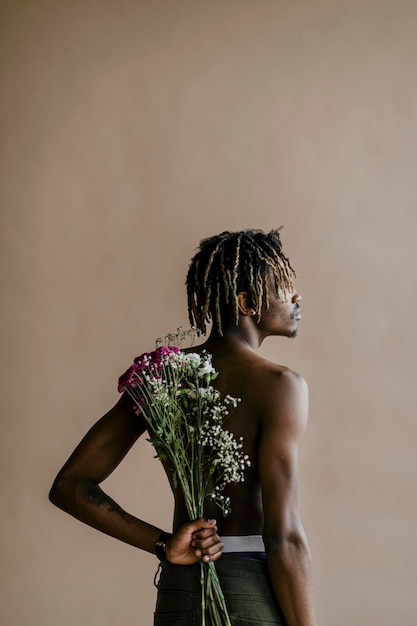Черный мужчина с букетом цветов на спине