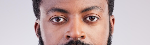 Photo black man eyes and face portrait in studio for vision focus and serious expression to stare african male person on a grey background for eyesight determination and awareness of unique identity