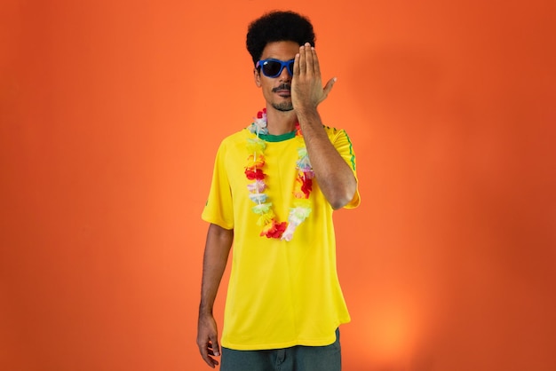 Black man football fan Man in yellow shirt isolated on orange background