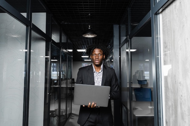 Black man freelancer with laptop in coworking space. Online working on laptop.