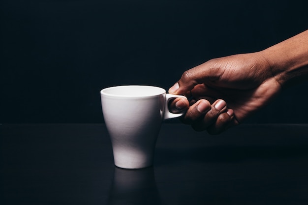 Mano uomo nero tazza irriconoscibile tè bianco caffè spazio libero contrasto colore concetto