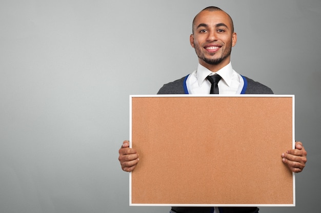 Black man holding a cork board