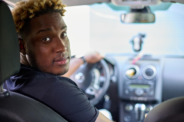 Black man is sitting in car and driving