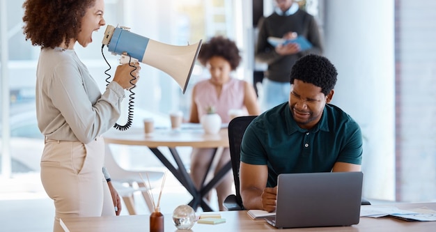 Black man laptop and boss on megaphone angry or shouting at employee Loudspeaker leader and business woman with bullhorn screaming at stressed or frustrated worker to start work at company office