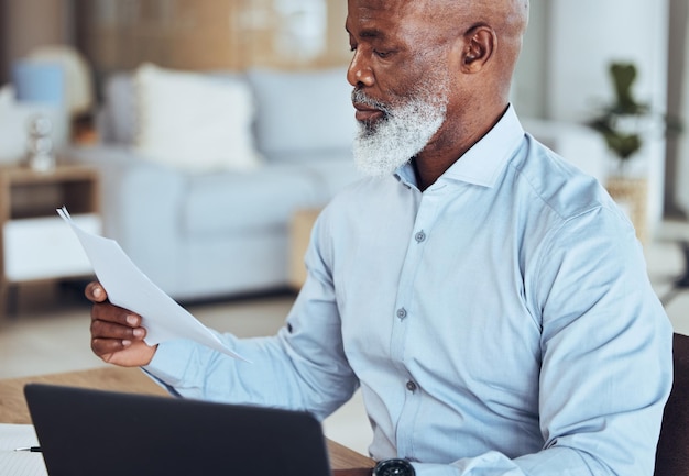 Black man laptop or reading documents in corporate office for company finance budget taxes audit or financial management Mature CEO boss or businessman with technology paper or investment report