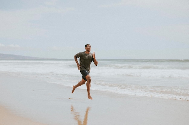 Uomo di colore che corre sulla spiaggia