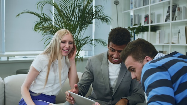 Black man sharing good news with coworkers.