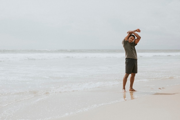 Photo black man stretching on the beach