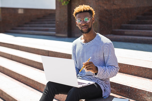 Black man studying on stairway