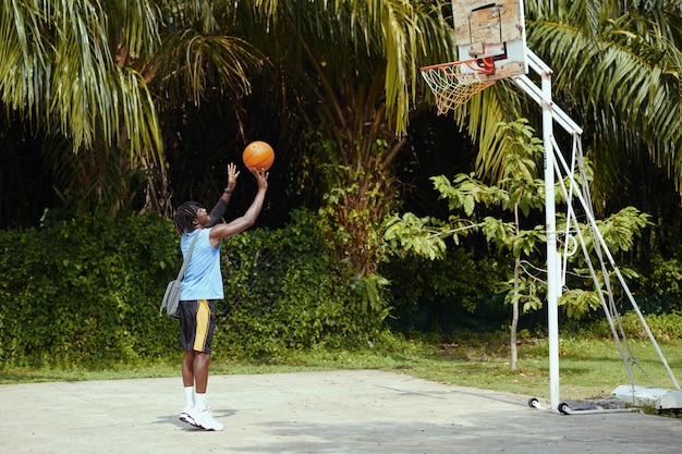 Black man throwing ball in basket