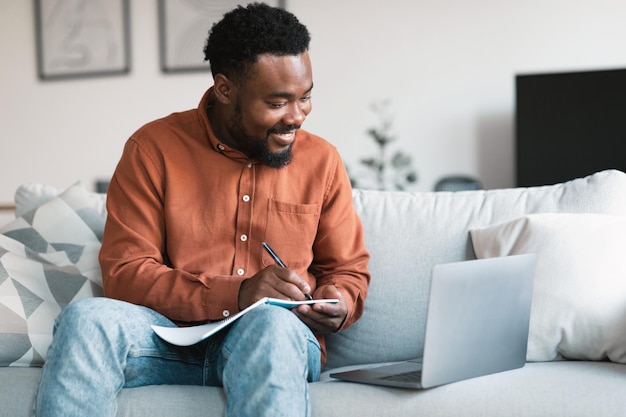Черный Человек Используя Ноутбук Делает Заметки Обучение Онлайн Дома