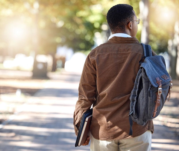 Photo black man walking or backpack on campus park nature or garden for college university or school studying development student gen z and person with learning books education bag or growth mindset