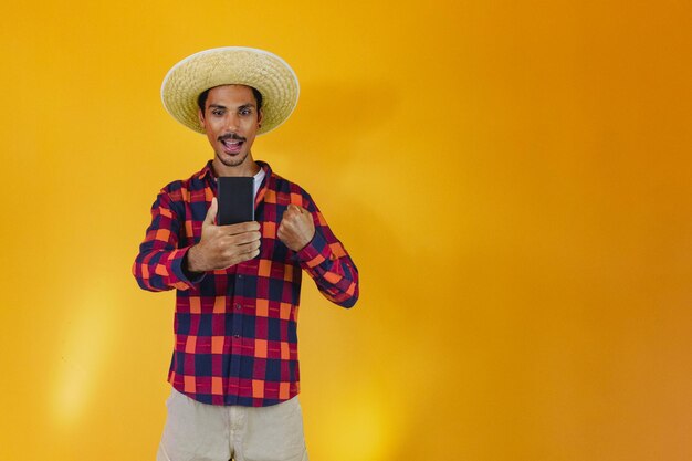 Black man wearing traditional clothes for Festa Junina isolated on yellow