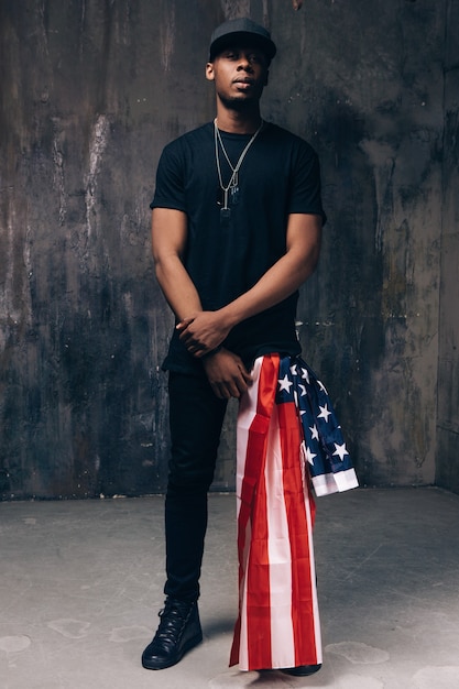 Black man with american flag as accessory on dark background