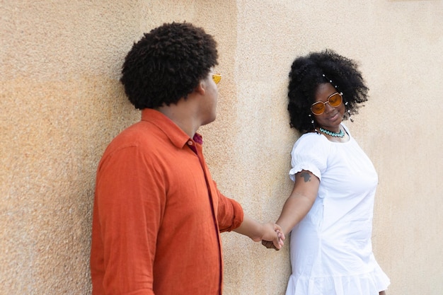 Black man with standing next to afro woman both smiling