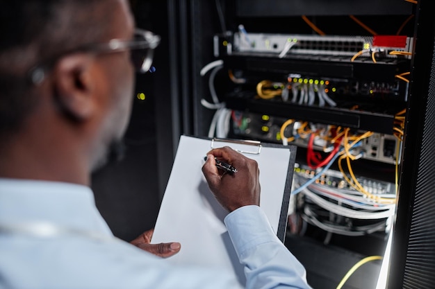 Black man working with server cabinet in data center