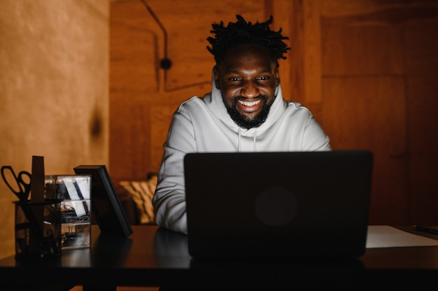 A black man works at a laptop close-up of his face. video conferences.