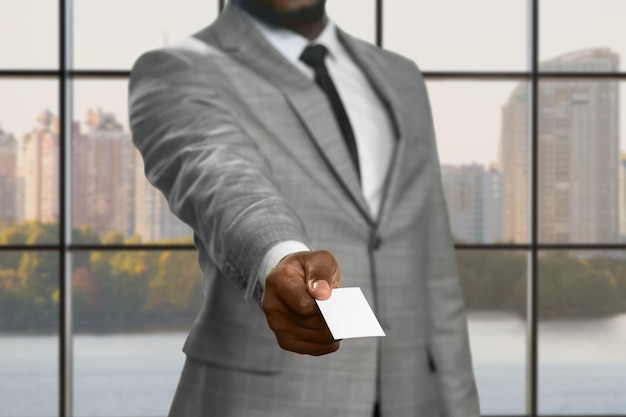 訪問カードを持っている黒人マネージャー。訪問カードを持つ浅黒い肌のビジネスマン。ビジネスエージェントの日中の仕事。弁護士がビジネスセンターに来ました。