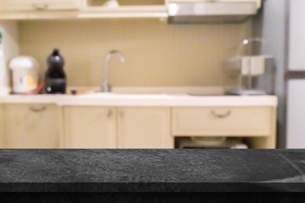 Photo black marble stone counter top with blurred kitchen background