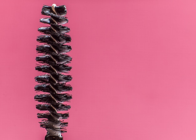 Black mascara brushes, isolated on pink. 