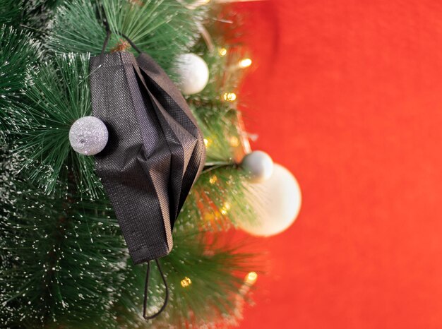 Premium Photo | Black mask hung on the christmas tree ...