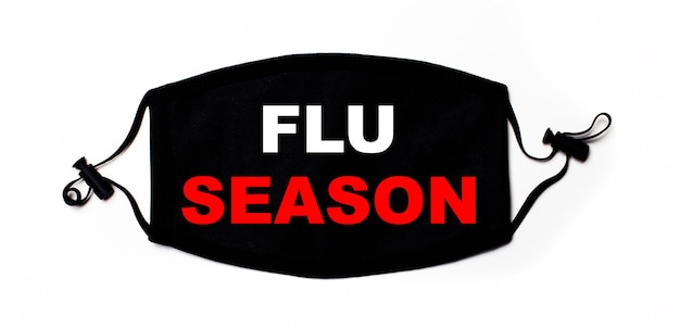 사진 비문 flu season이있는 밝은 표면에 검은 색 의료 얼굴 마스크. 질병 예방. 의료 개념