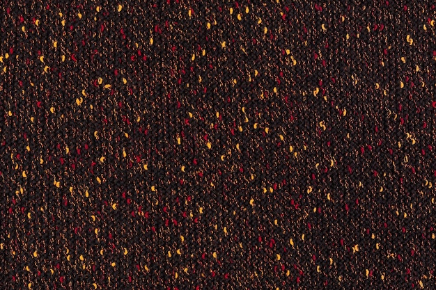 Black melange manually knitted fabric with red and yellow\
blotches seamless texture and flat background