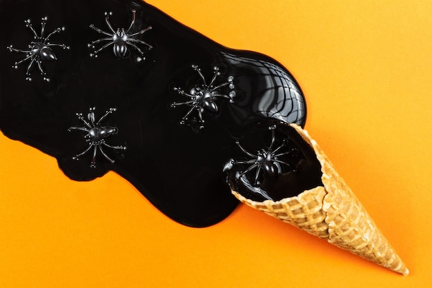 Black melting ice cream on orange background. Halloween concept.