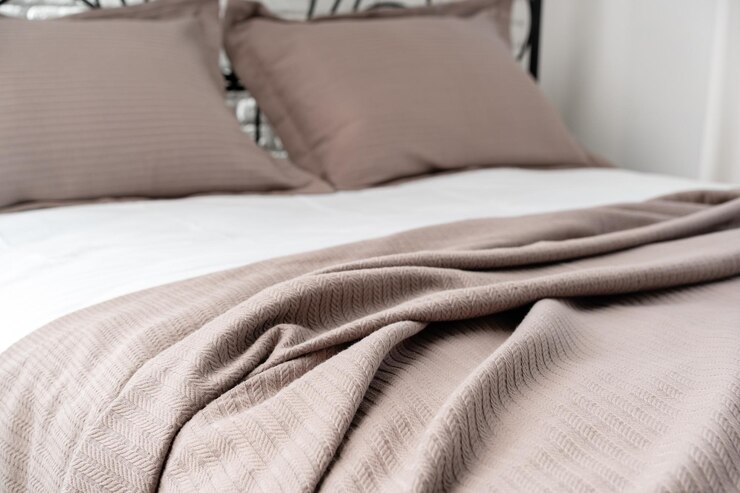 Photo black metal bed frame with white and beige bedding in a modern bedroom