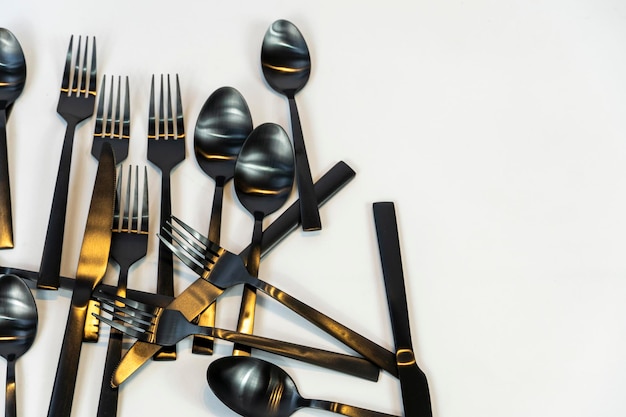 Black metal Dinnerware Cutlery Utensils Forks Knives Spoons on Gray Background mexcio
