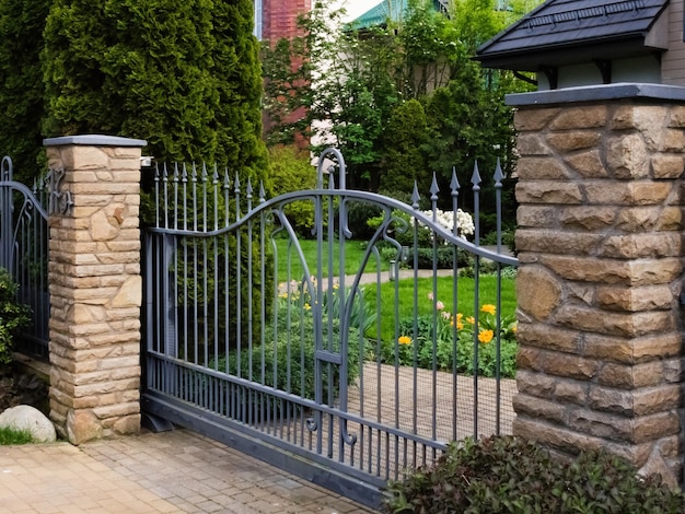 black metal fence with gate and yellow facing brick