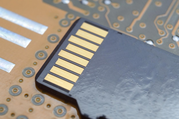 The black micro sd card lies on the microcircuit. close-up.