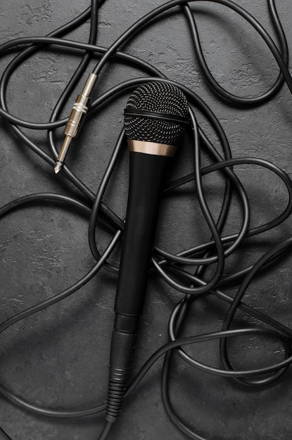 Black microphone on a dark concrete table. Equipment for vocals or interviews or reporting