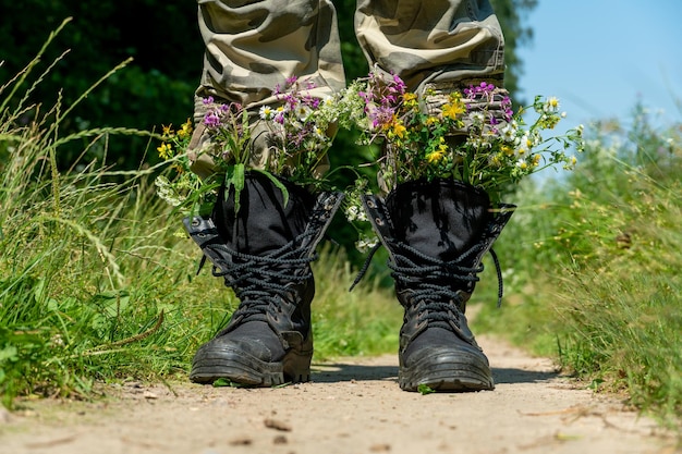 총알과 전쟁 대신 꽃이 든 검은 군용 부츠 우크라이나 전쟁 종료 러시아 군대의 항복과 우크라이나 영토에서 군대 철수