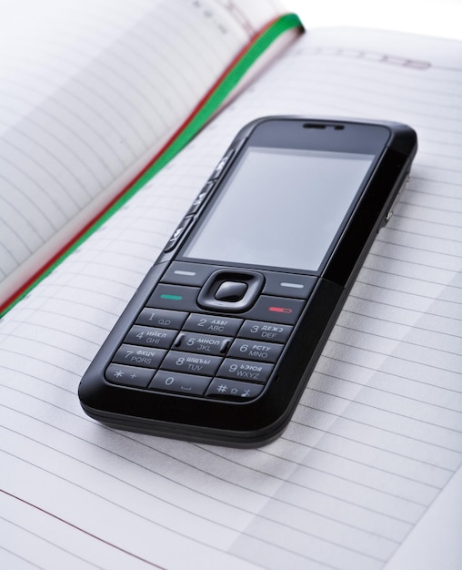 Black mobile phone on a notepad