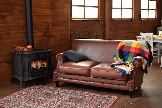 Stufa a legna in ghisa moderna nera a casa e comodo divano nell'accogliente soggiorno interno