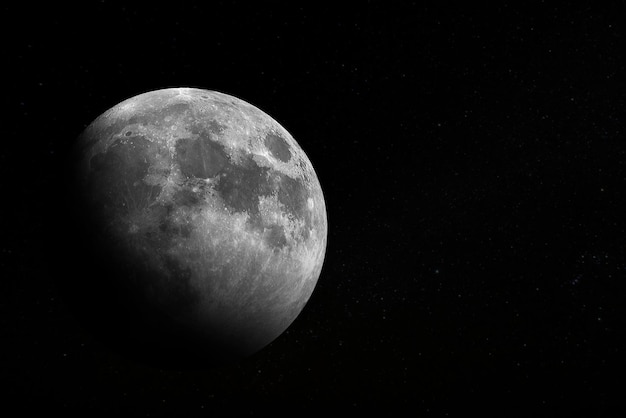 A black moon is seen in a black sky with stars.