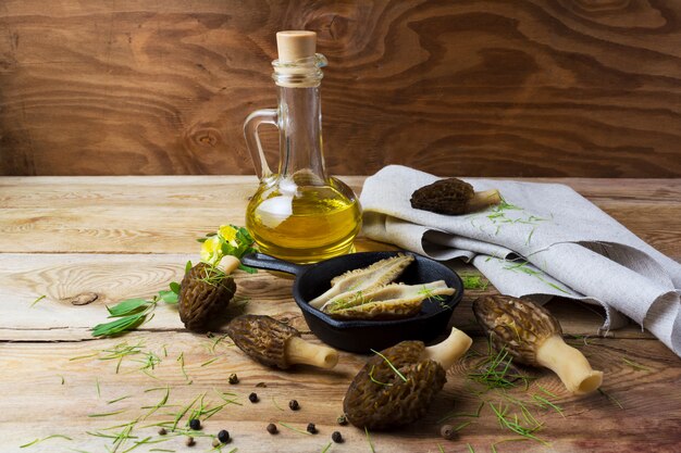 Black morel in skillet on rustic background.