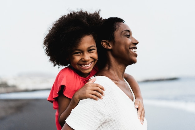 夏休みに屋外で一緒に楽しんでいる黒人の母と娘-女の子の顔に焦点を当てる