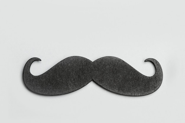 Photo a black moustache on a gray background