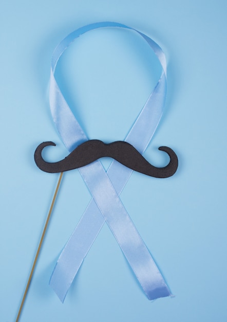 Black moustache on a wooden stick and a blue ribbon