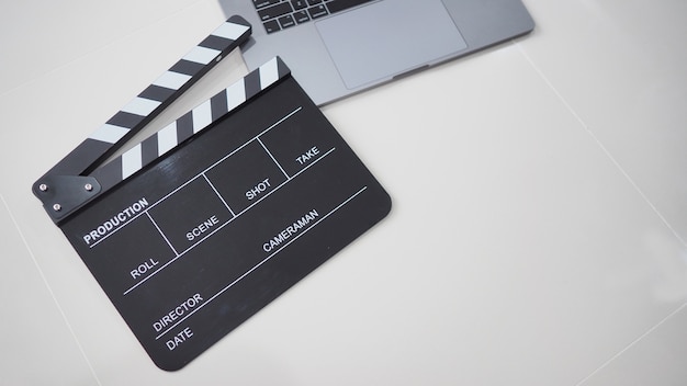 Photo black movie slate or clapperboard and laptop use in video production ,film, cinema industry on white background.