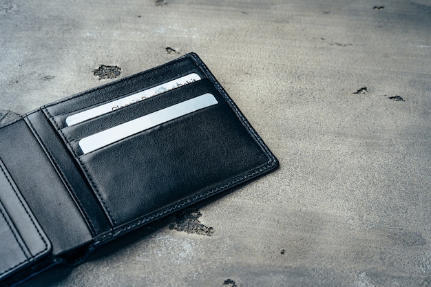 Black new leather wallet on grey concrete background