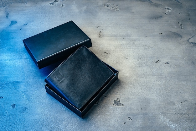 Black new leather wallet on grey concrete background