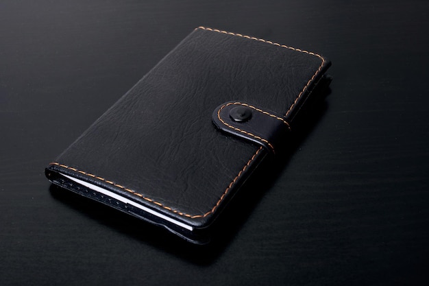 Black notebook on a black wooden table