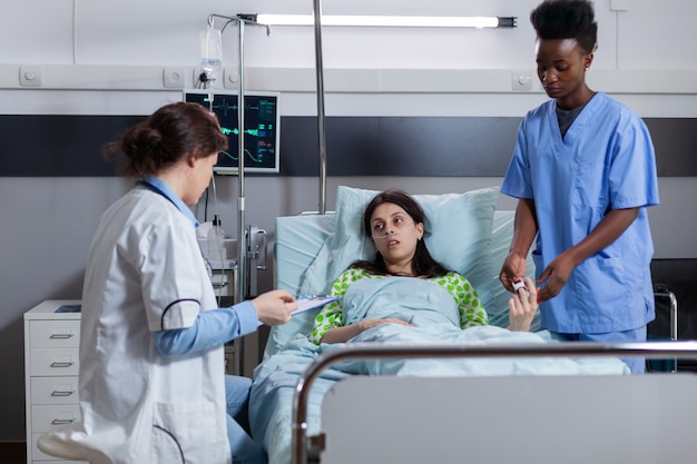 Black nurse puts oximeter on finger monitoring heartbeat pulse