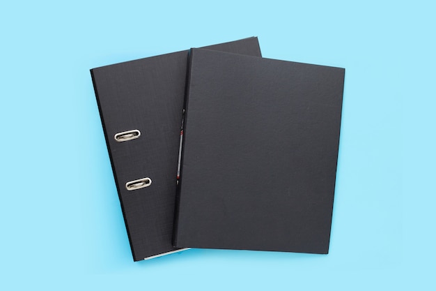 Photo black office folders on blue background. top view