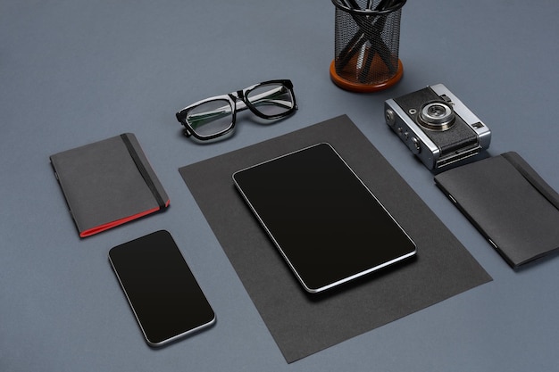 Black office stuff collection flat lay. Top view on set of stationery with smartphone and tablet. Modern life, communication, time-management, technologies concept