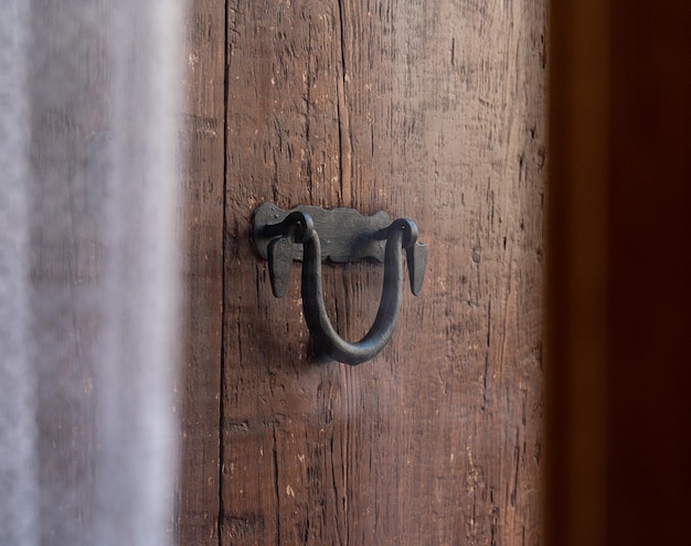 Black old door handle over a brown wooden door